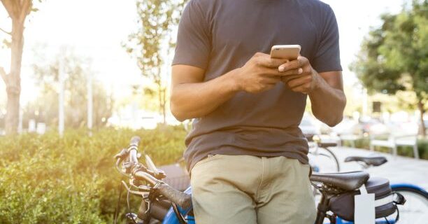 Man leaning against bicycle on his cell phone