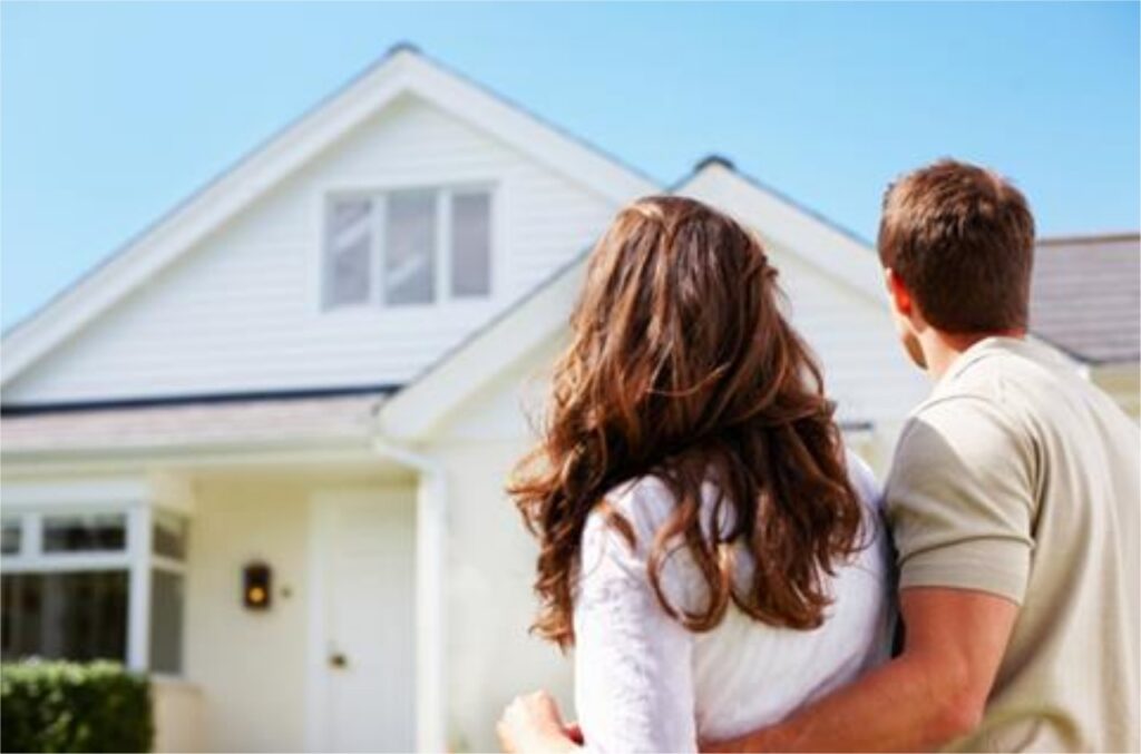 Man with arm around woman while looking at a new house