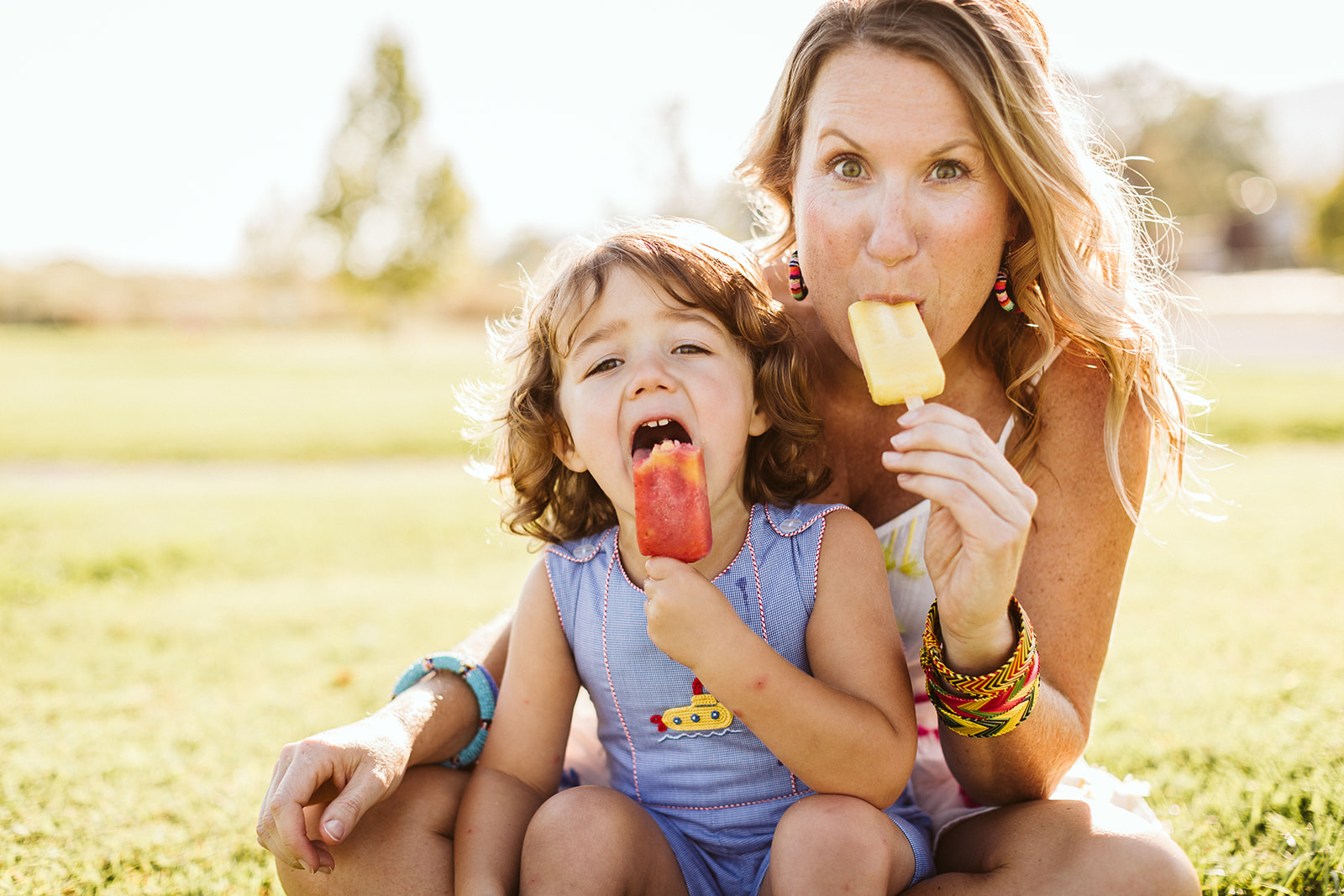Mom and daughter enjoy an ice cream pop on a summer day