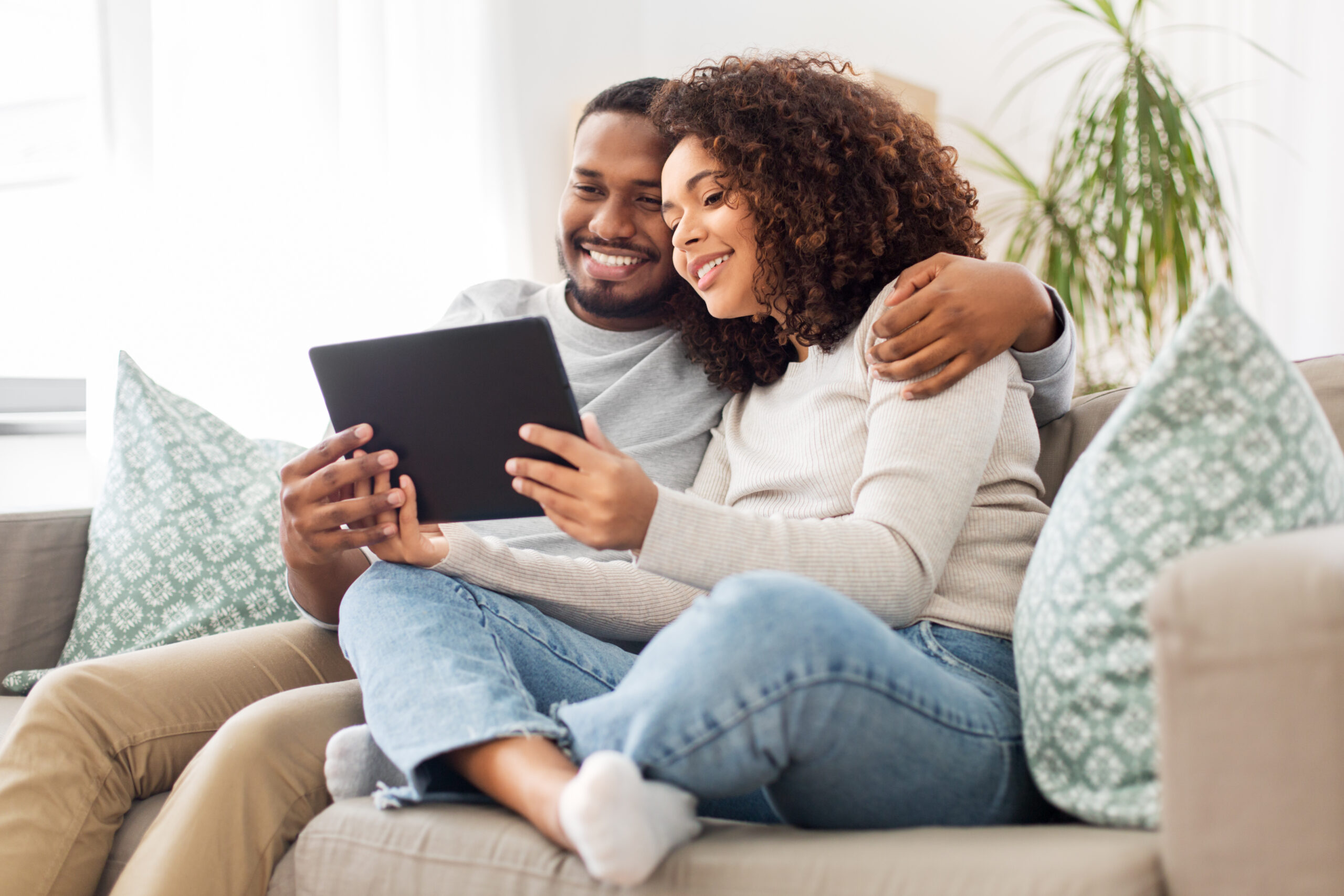 a young couple looks at their checking and personal loan accounts online.
