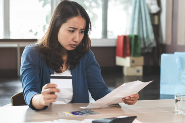 A woman reviews her finances and weighs the pros and cons of personal loans to pay off credit card debt.