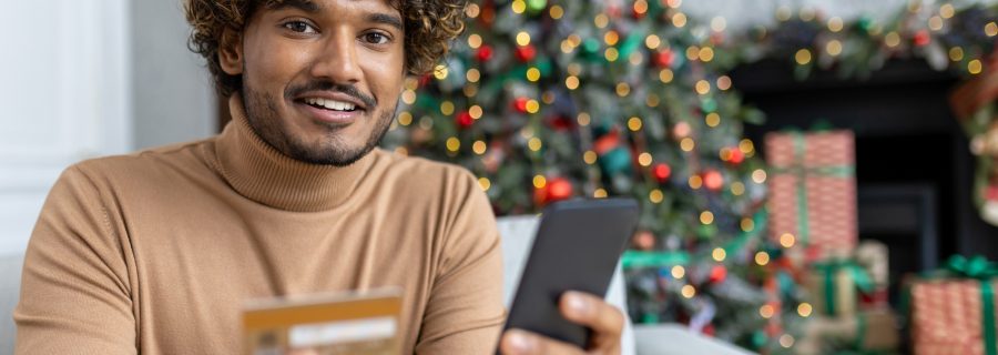 Man holiday shopping on phone after consolidating debts.