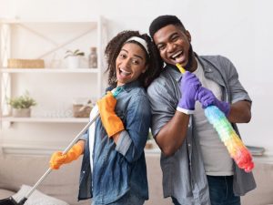 Happy couple cleaning their home