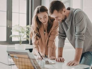 young couple reviewing home paperwork at the kitchen table