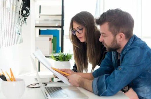 Two people reviewing paperwork together at a desk